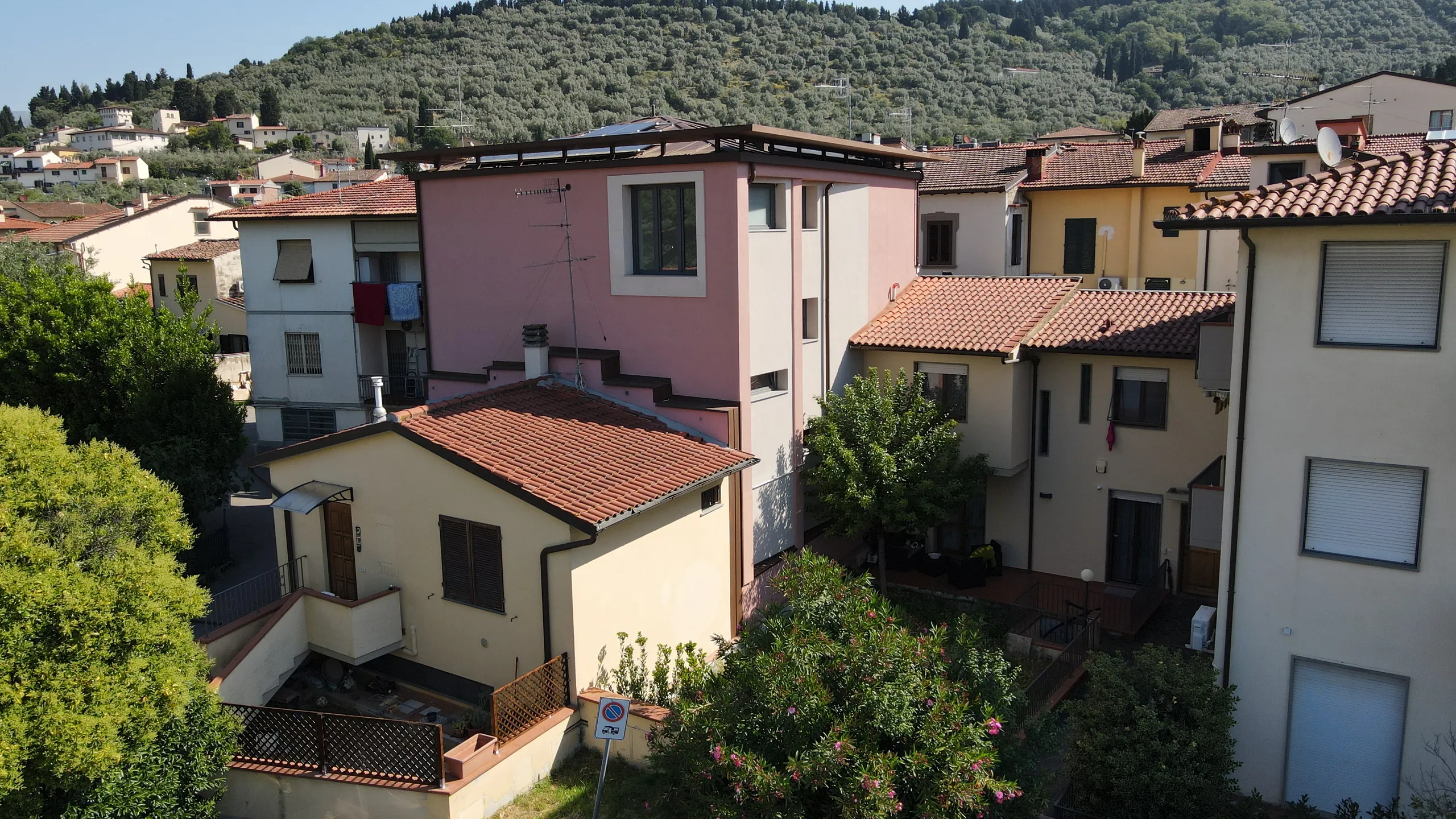Calenzano dopo l'intervento: la casa tra le case basse con le colline e gli ulivi alle spalle